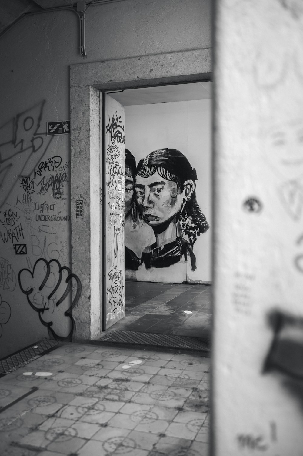 a black and white photo of a graffiti covered wall