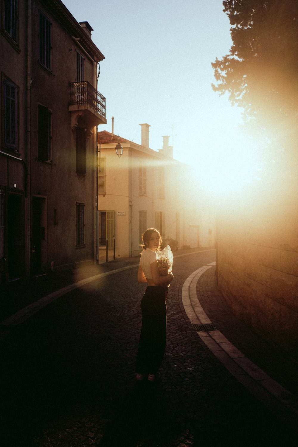 a woman holding a baby standing on a street