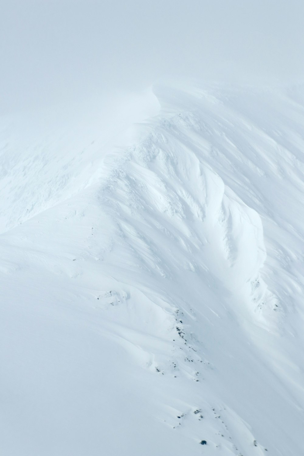 a man riding skis down the side of a snow covered slope