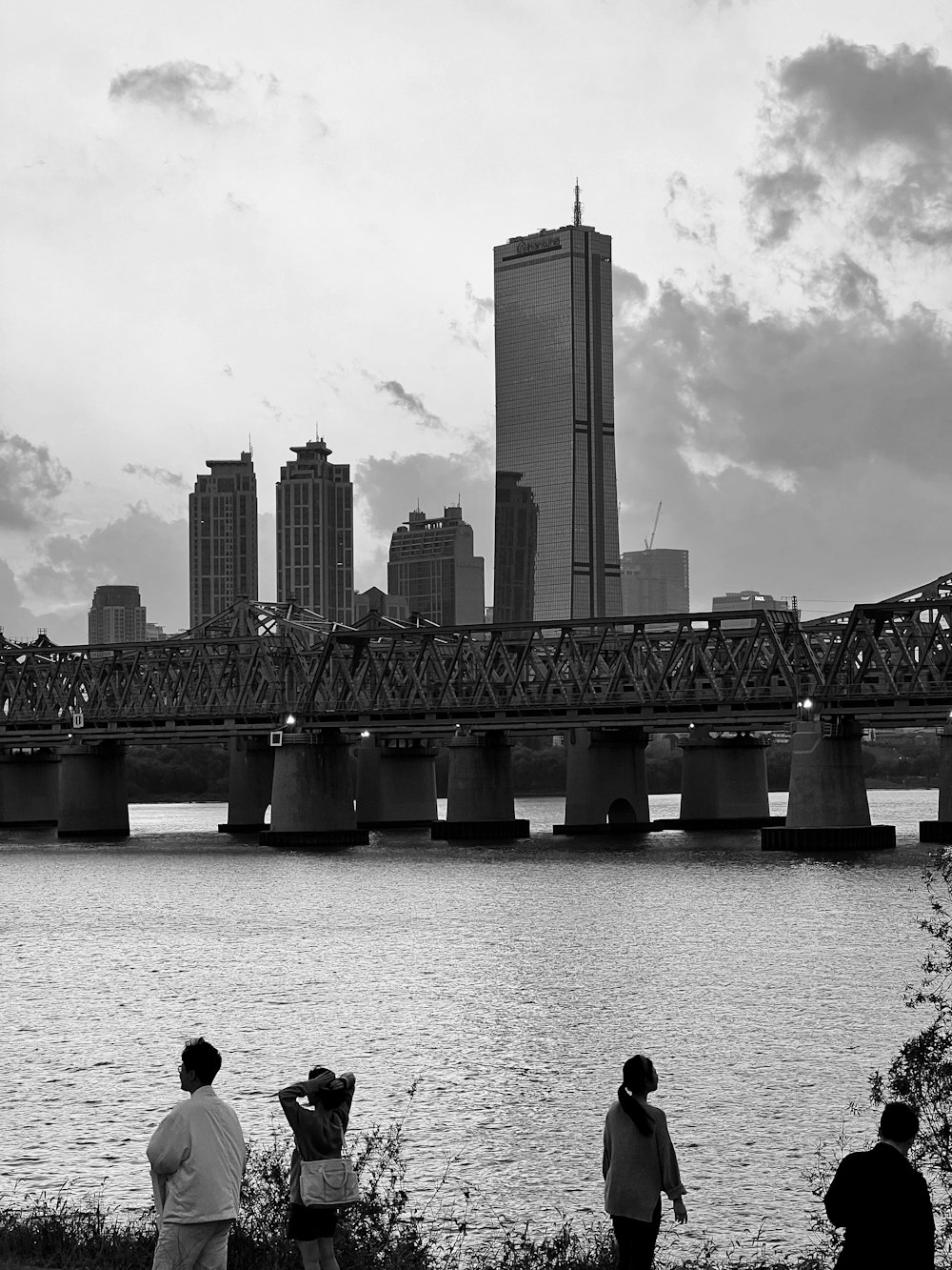 a black and white photo of a bridge over a river