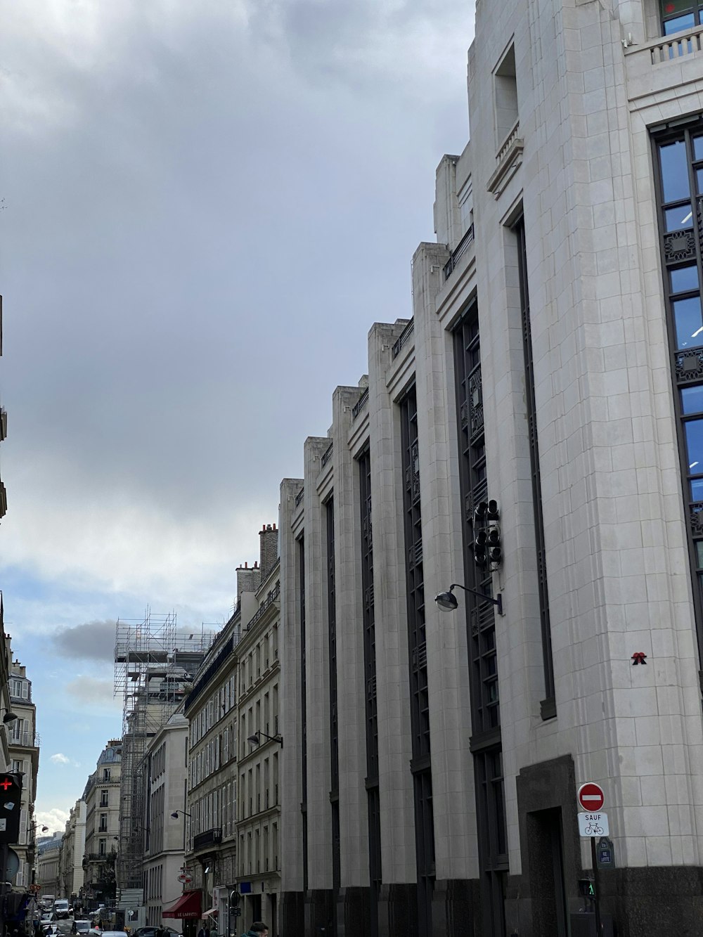 a city street lined with tall buildings under a cloudy sky