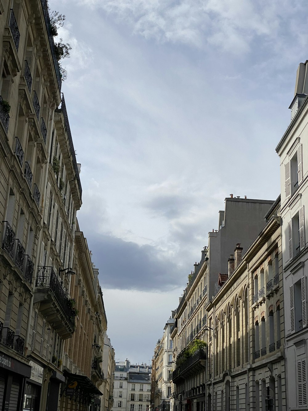 a city street lined with tall buildings under a cloudy sky