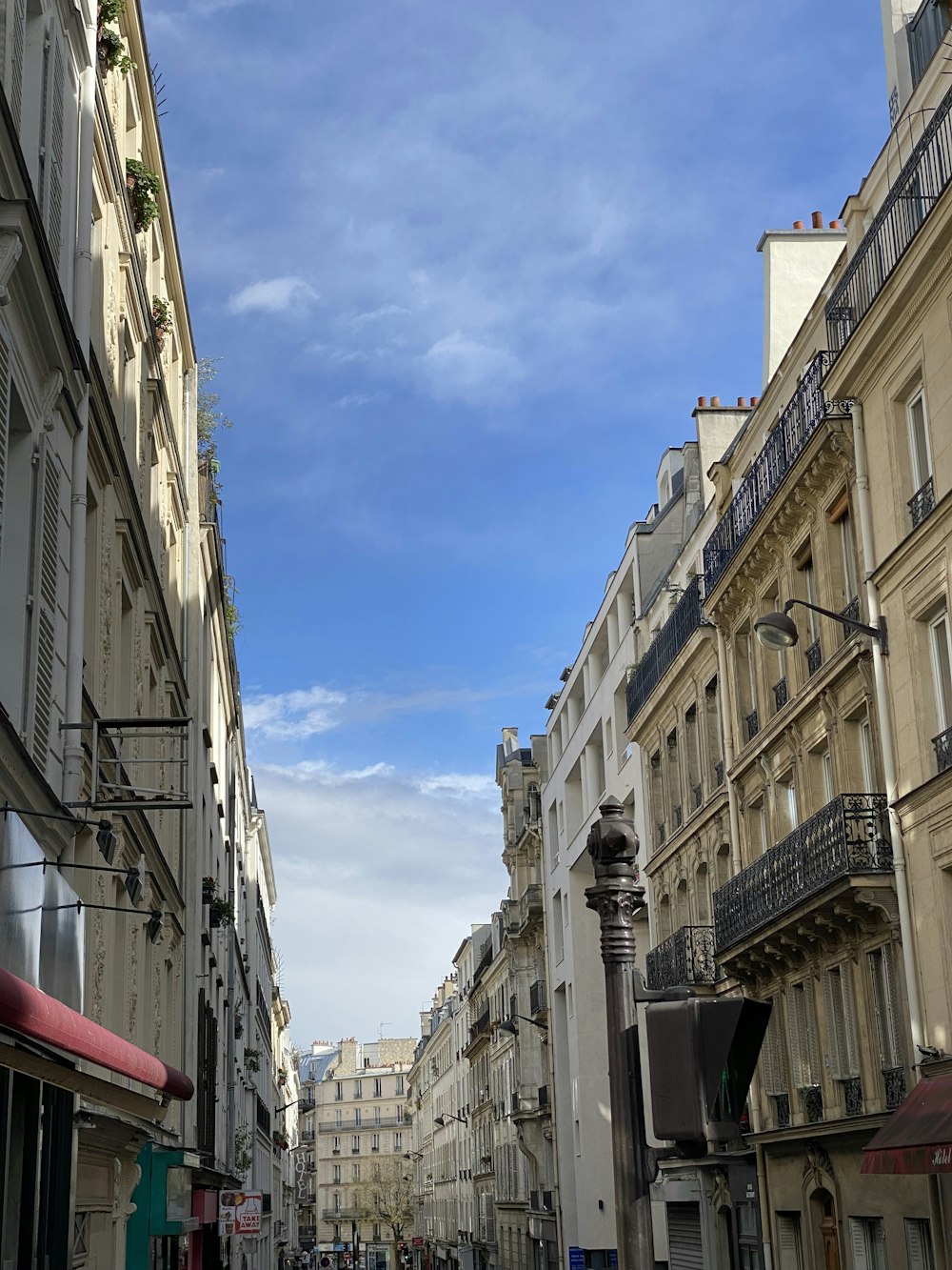 a city street lined with tall buildings under a blue sky