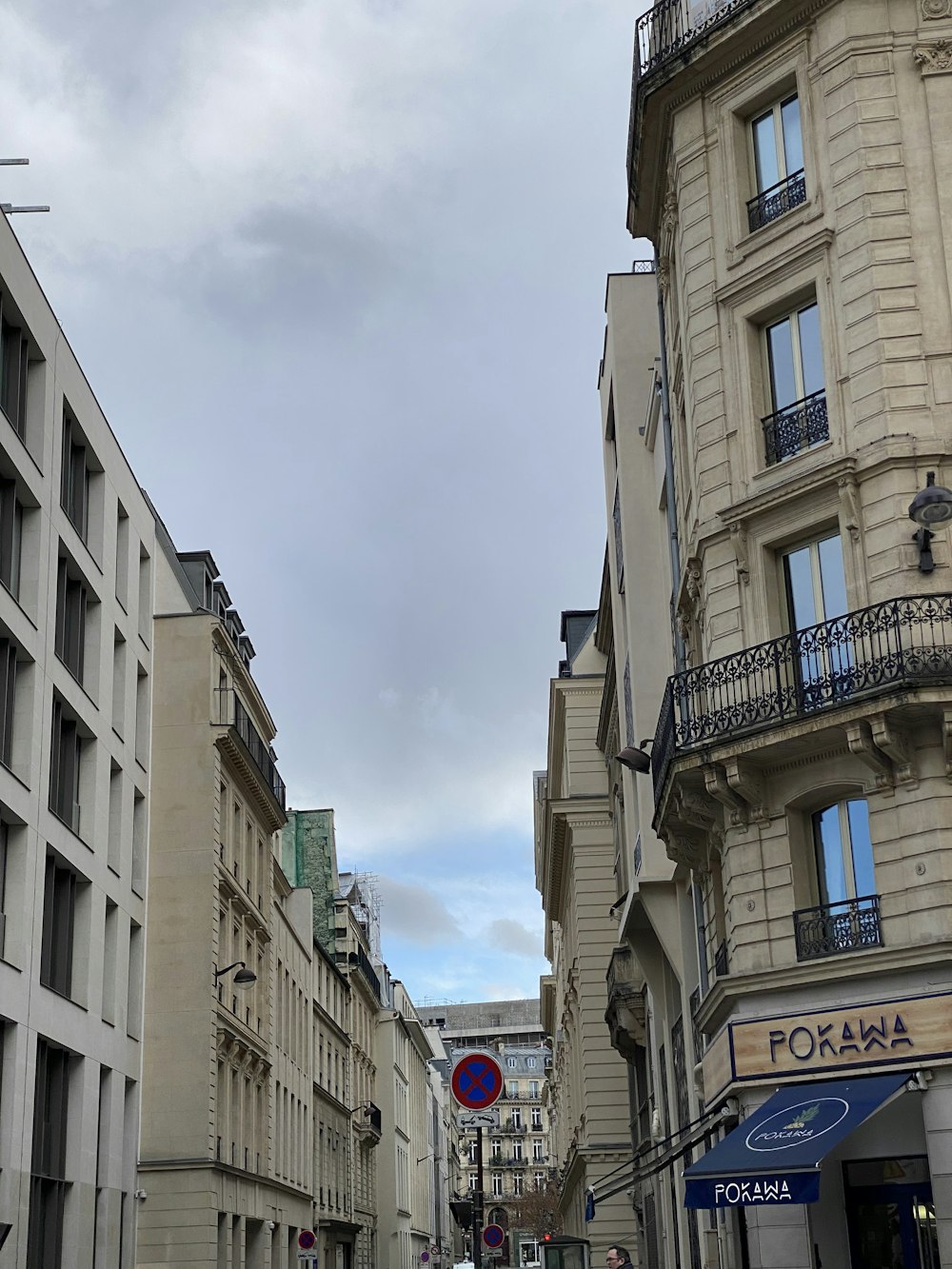 a city street lined with tall buildings under a cloudy sky