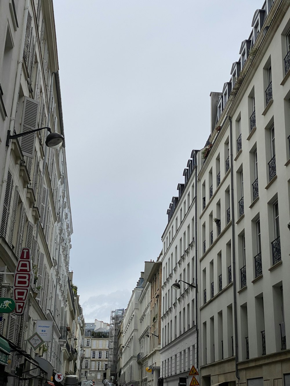 a city street lined with tall white buildings