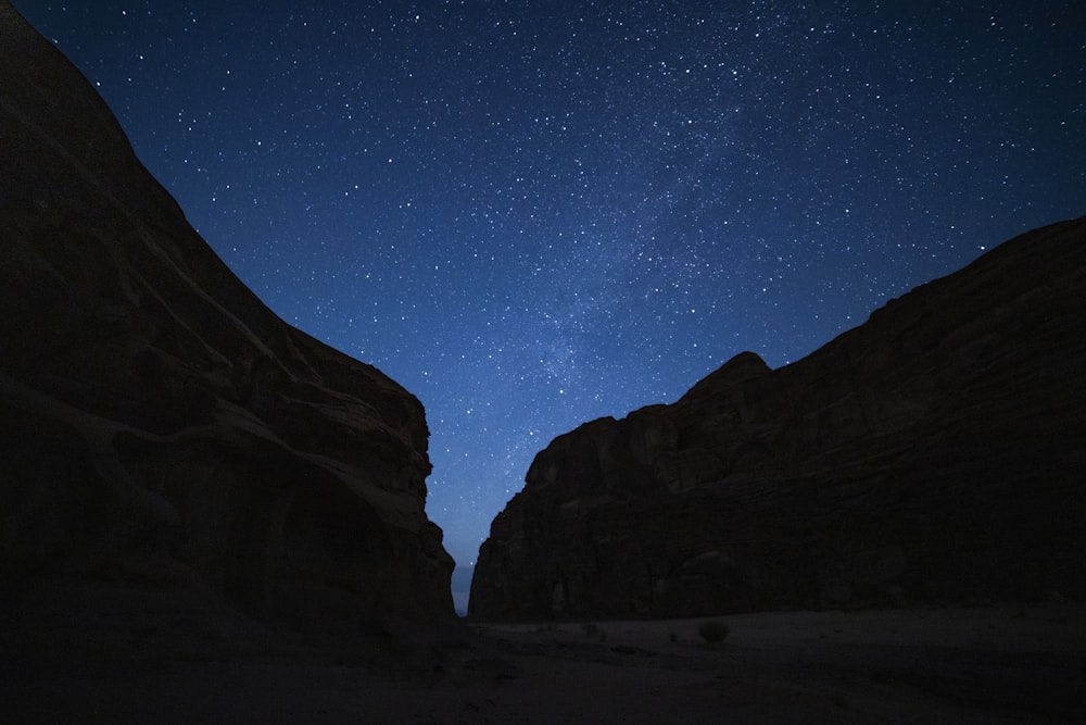 the stars shine brightly in the sky above a canyon
