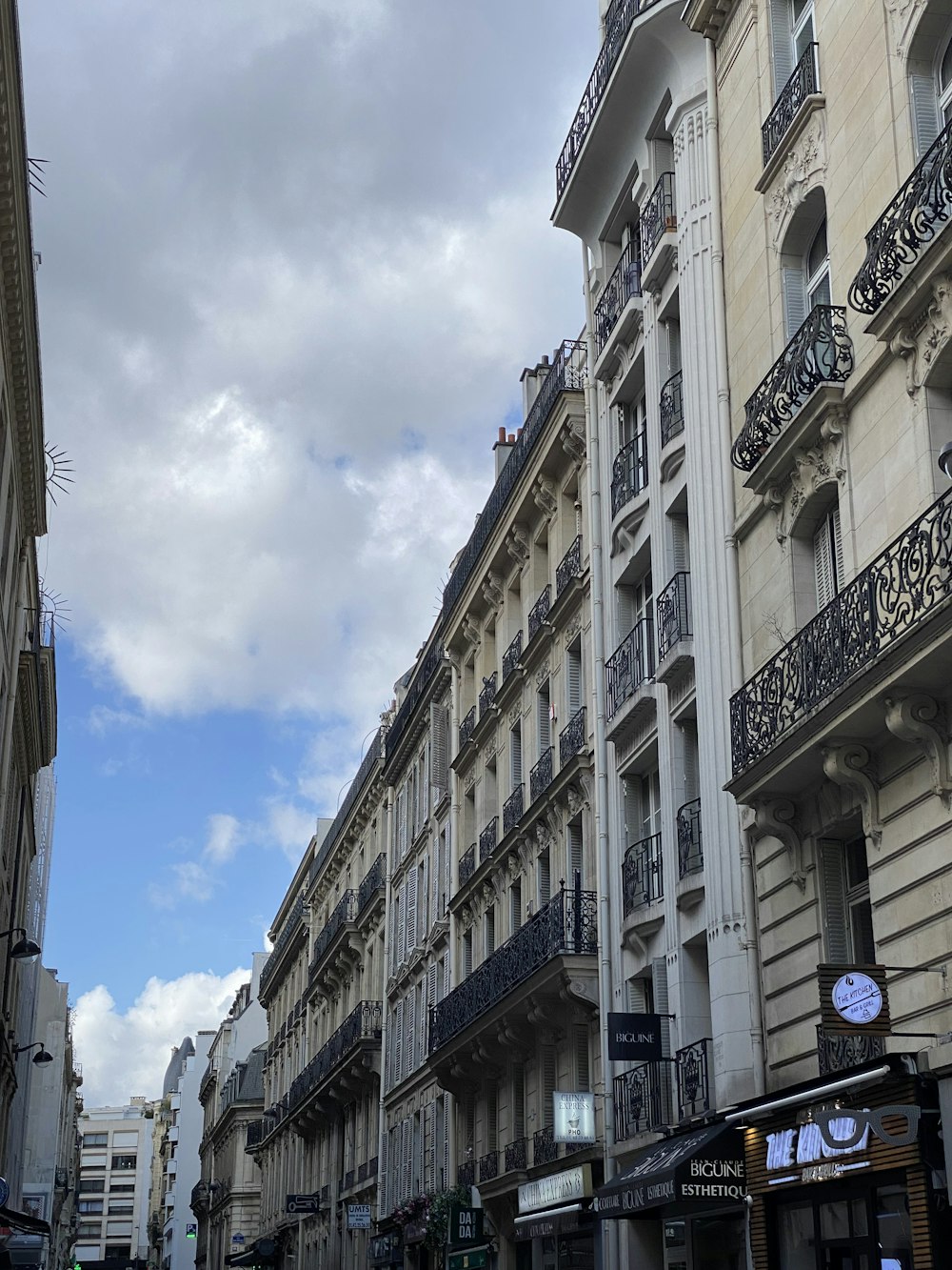 a city street lined with tall buildings under a cloudy sky