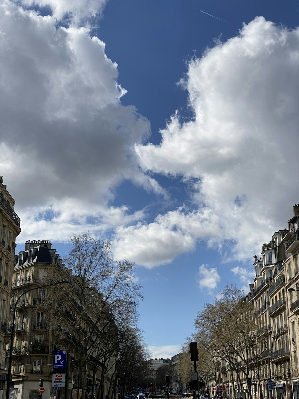 une vue d’une rue avec des bâtiments et un ciel nuageux