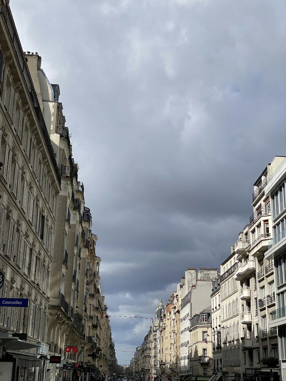 a street lined with tall buildings under a cloudy sky