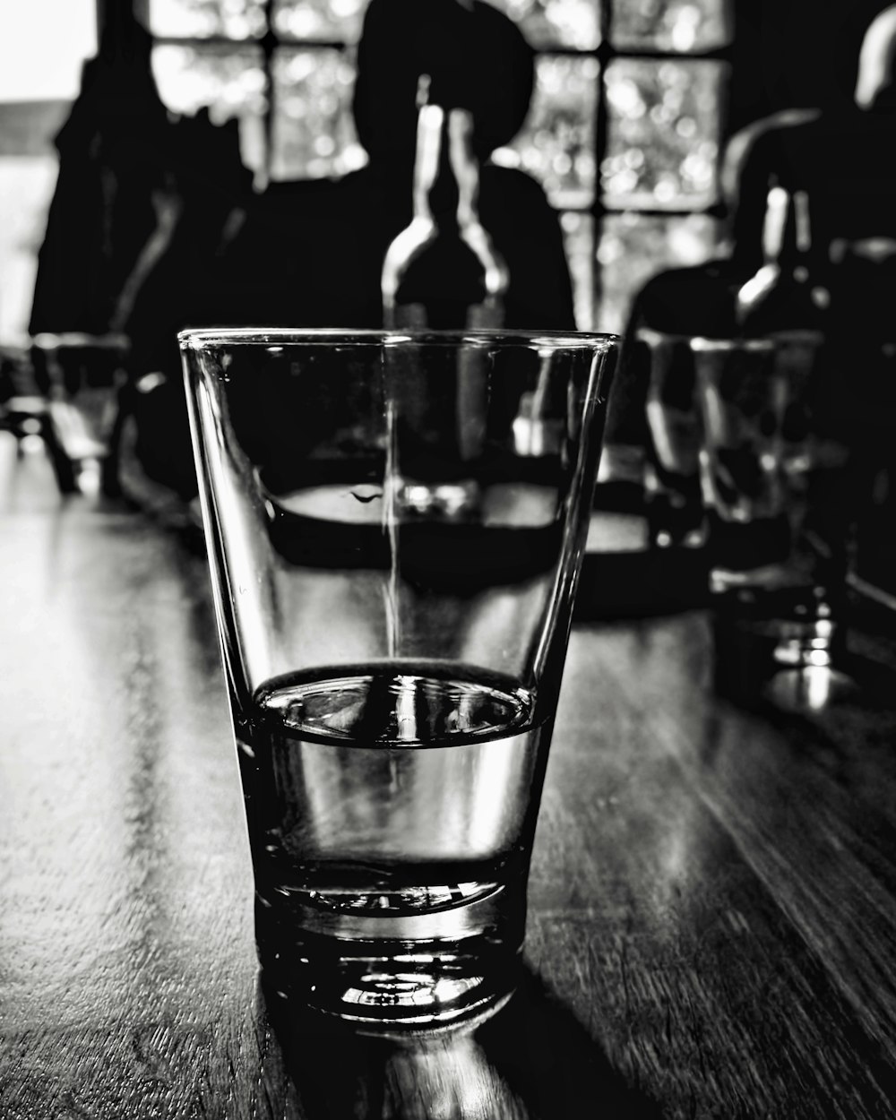 a black and white photo of a glass on a table