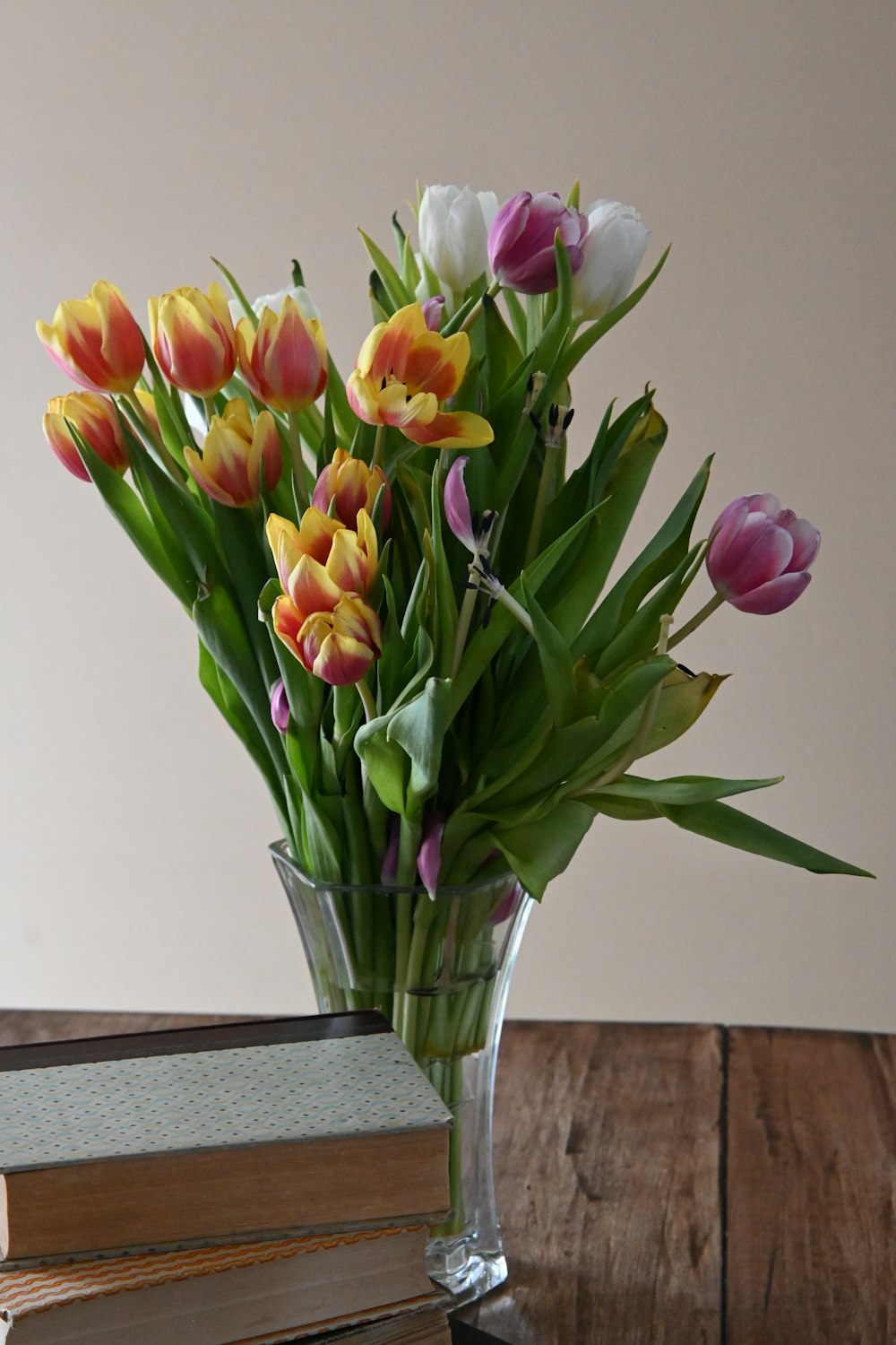 a vase filled with lots of colorful flowers on top of a table