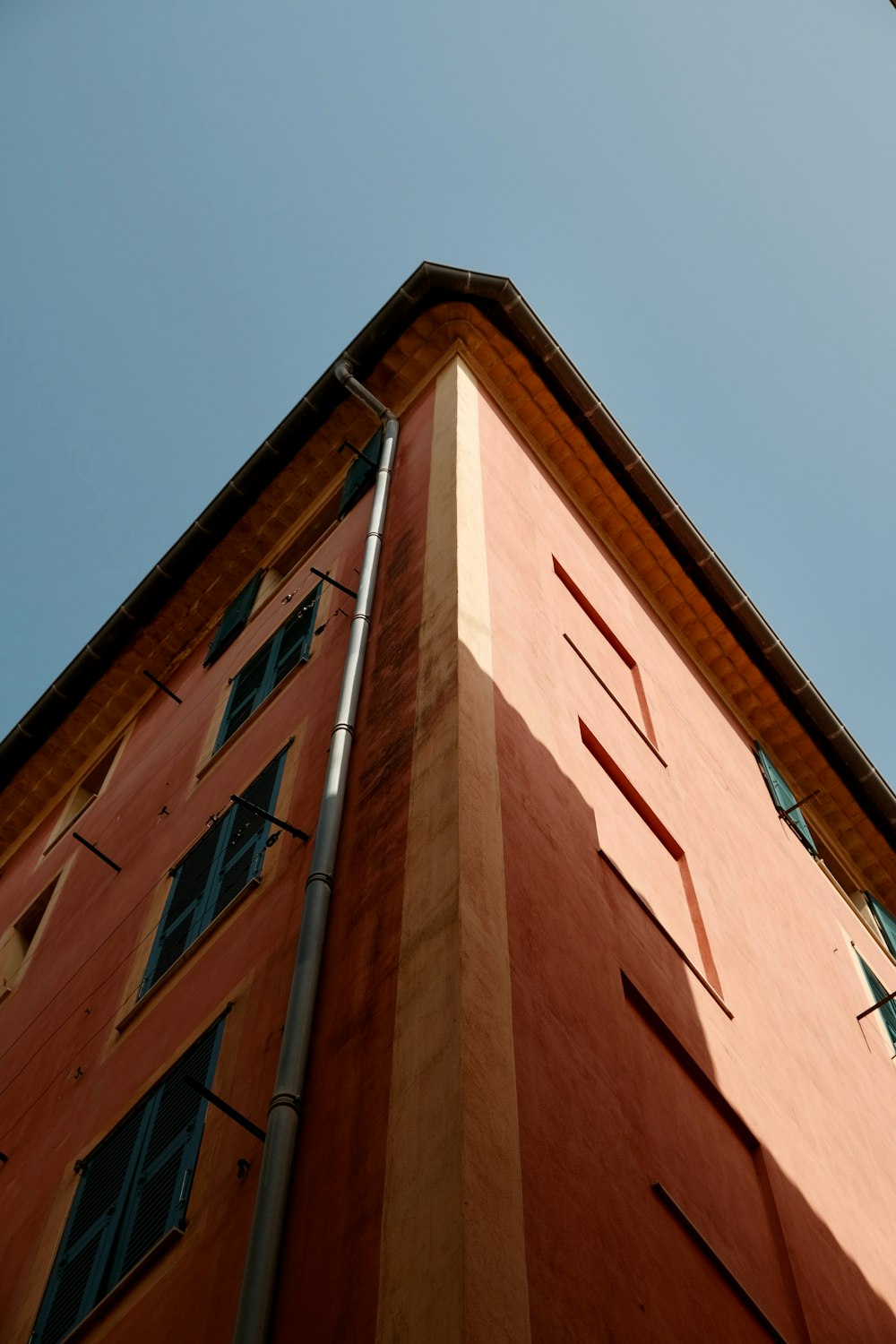 a tall orange building with a sky background