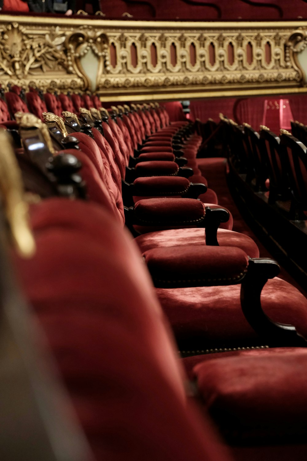 a row of red velvet seats in a theater