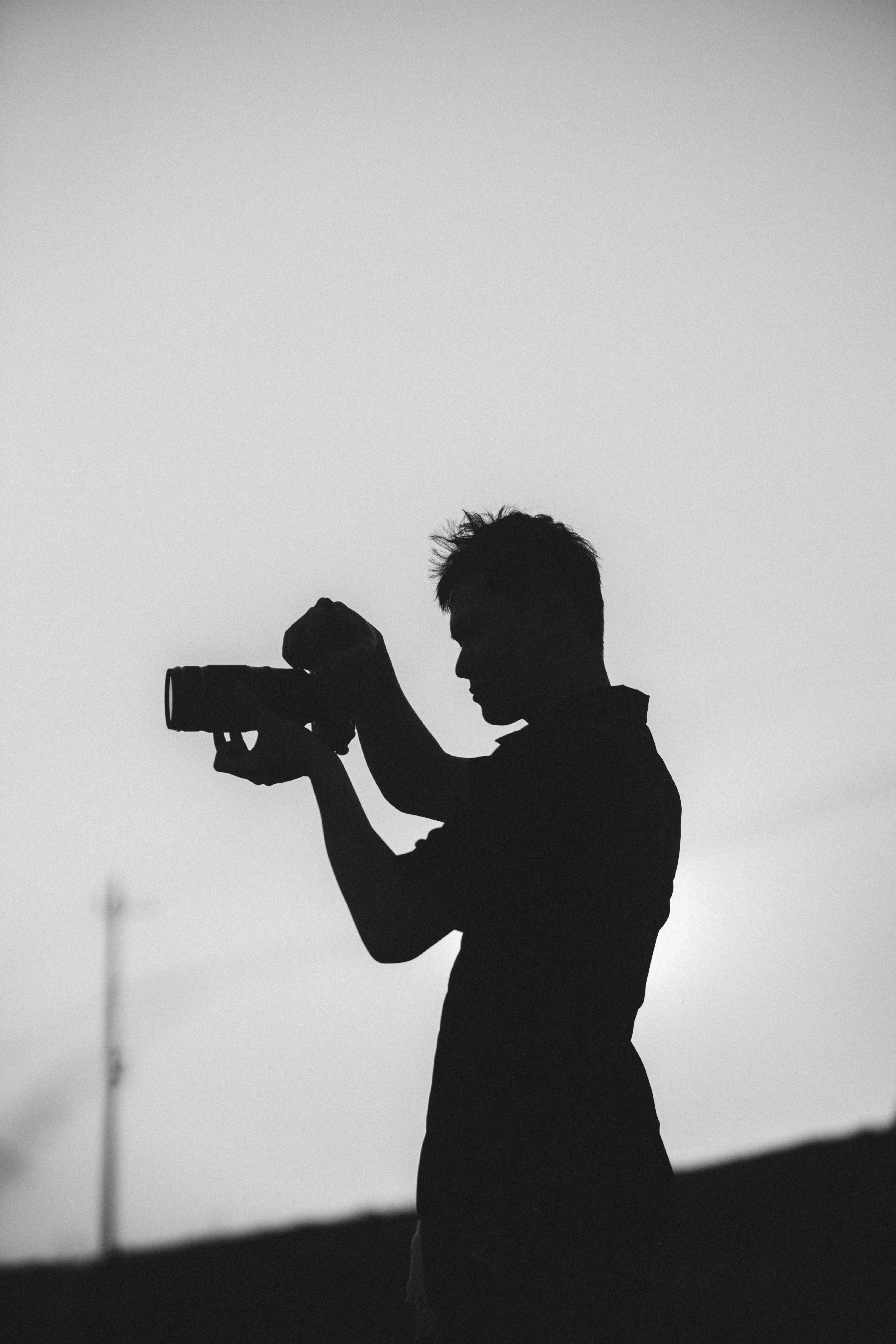 a black and white photo of a man holding a camera