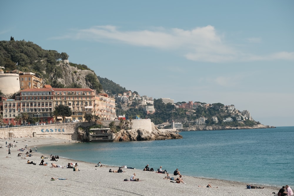 a group of people sitting on top of a sandy beach