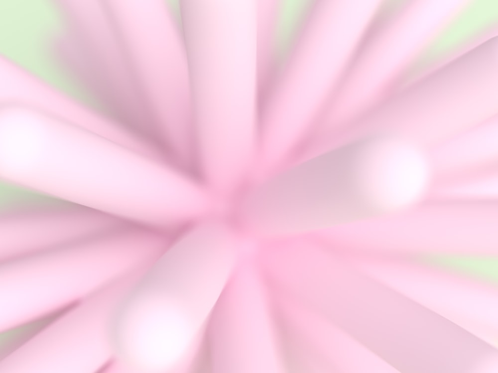 a blurry image of a pink flower on a green background
