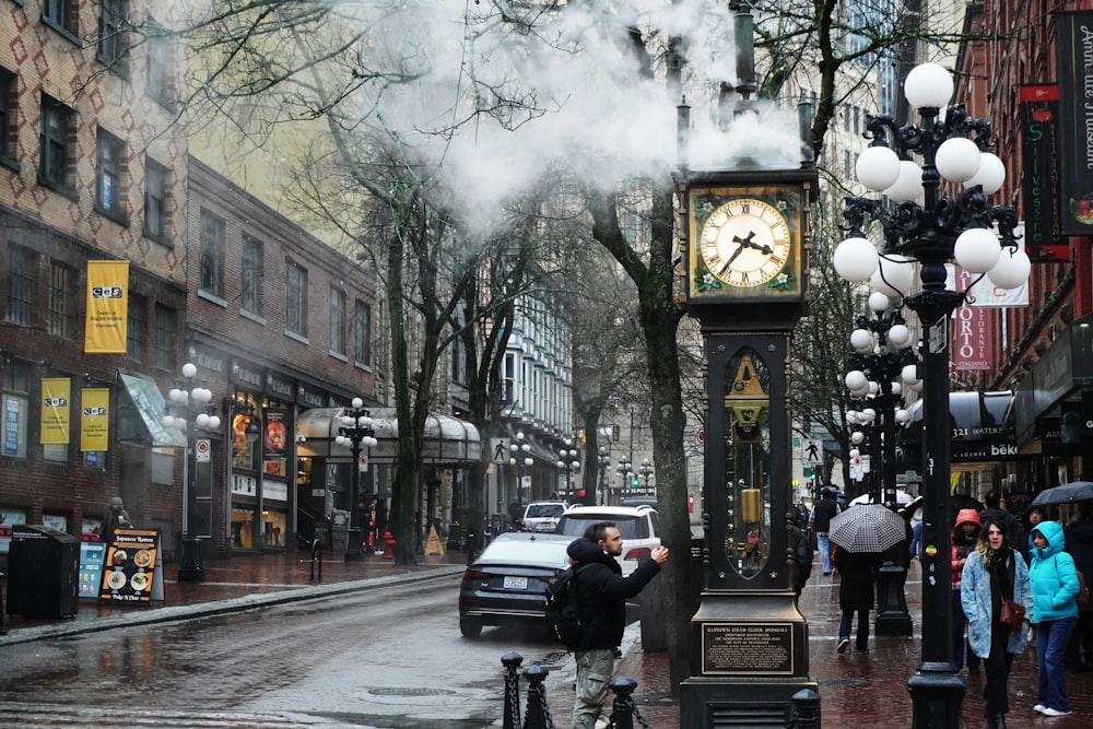 a clock tower on a city street with people walking around