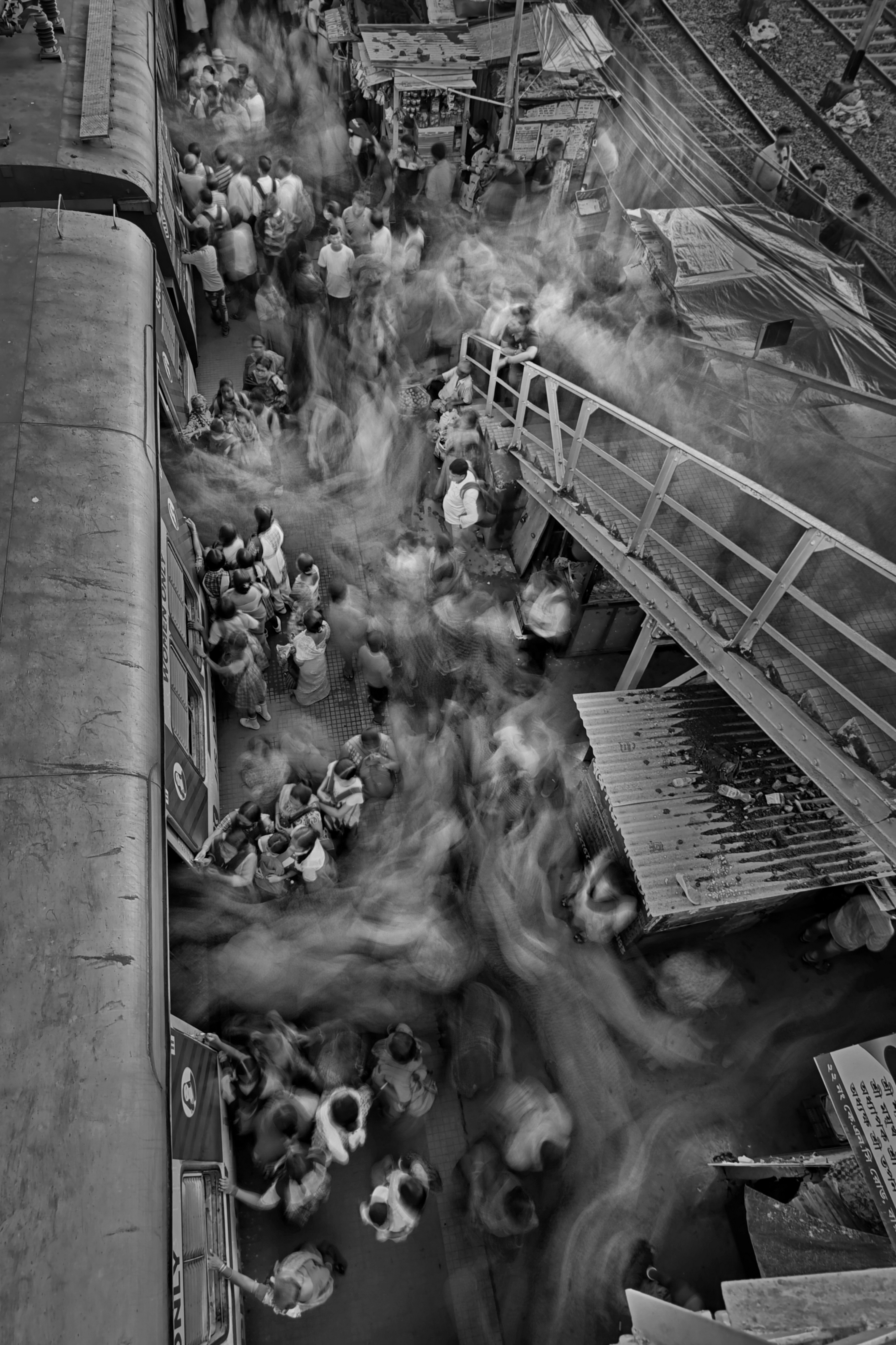 a black and white photo of people on a train platform