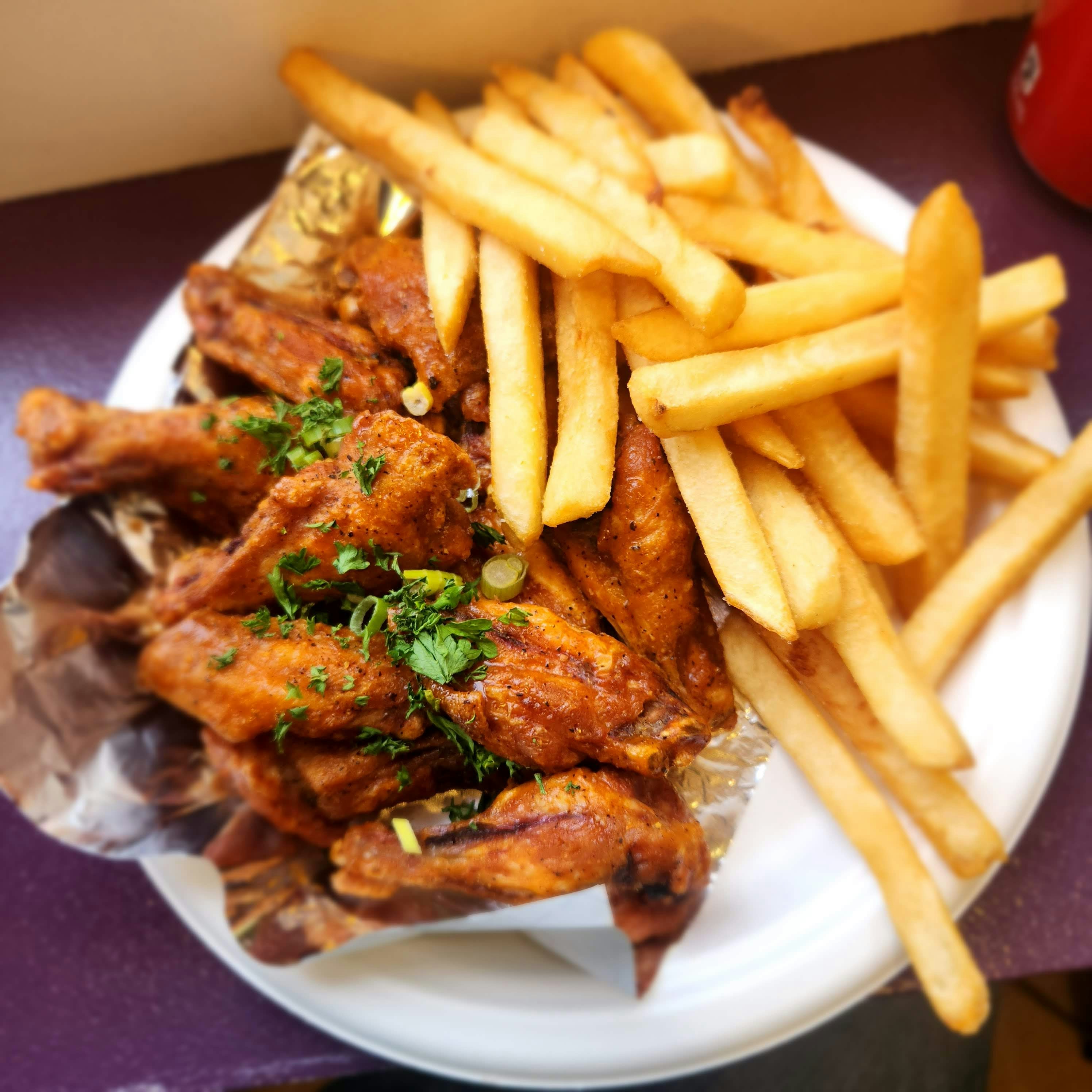 Alitas Frisby: doce alitas de pollo crujientes doradas con salsa BBQ y papas fritas