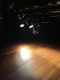 a wooden floor with lights on it in a dark room