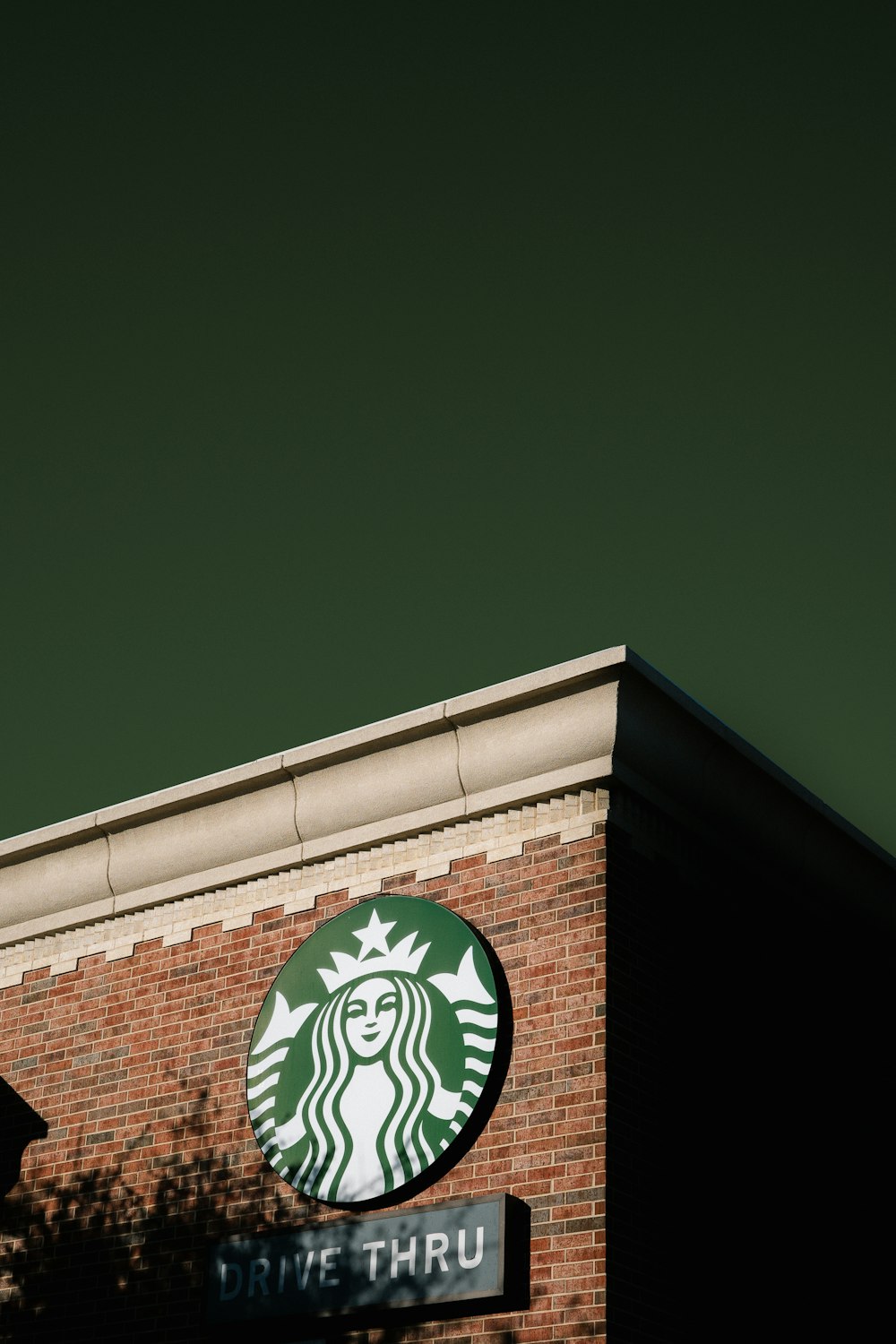 a starbucks sign on the side of a brick building
