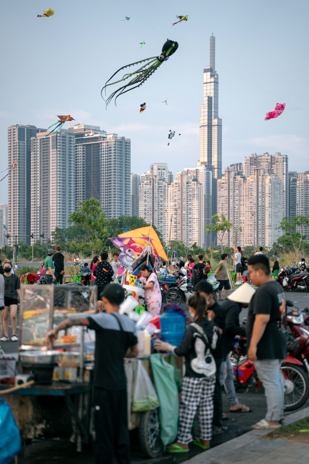 a group of people standing around a table with kites in the air