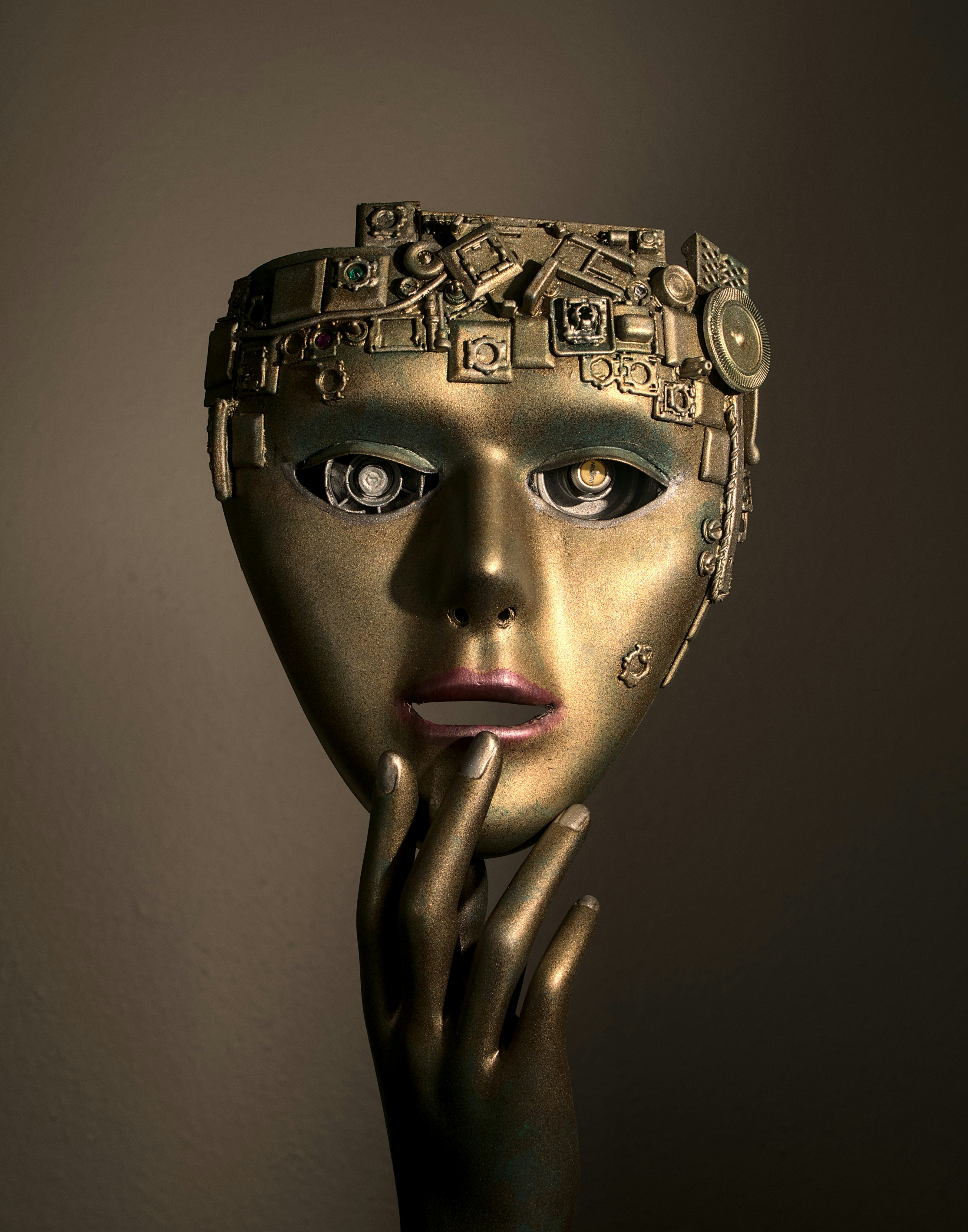 a woman's face with a gold mask on her head