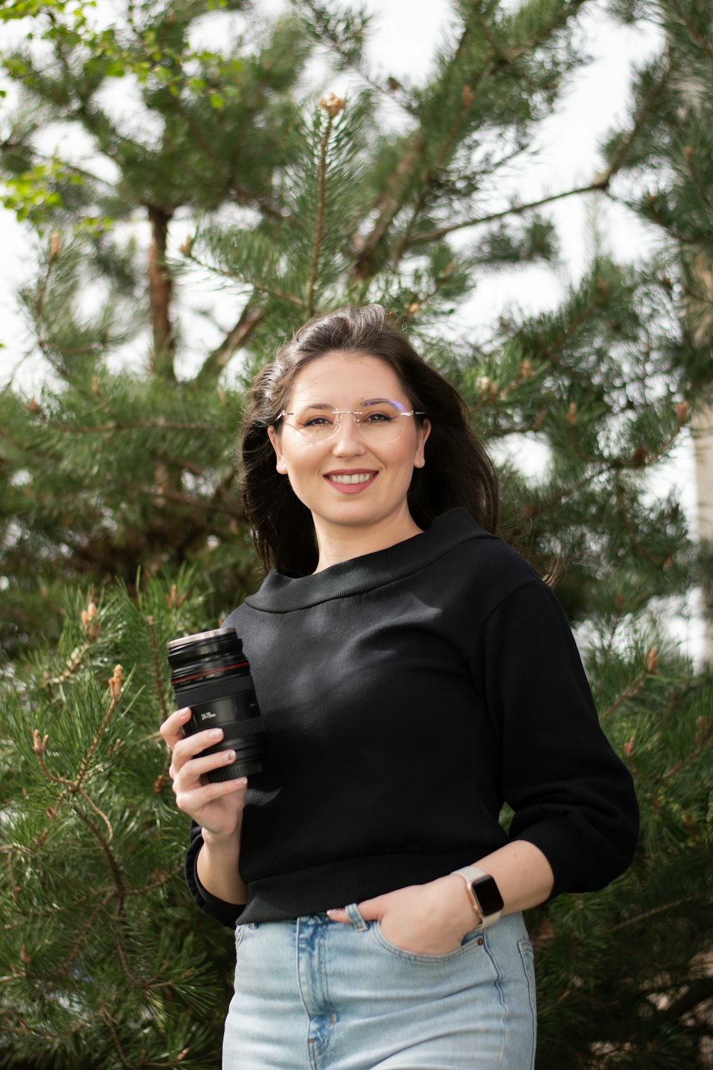 a woman in a black shirt is holding a cell phone