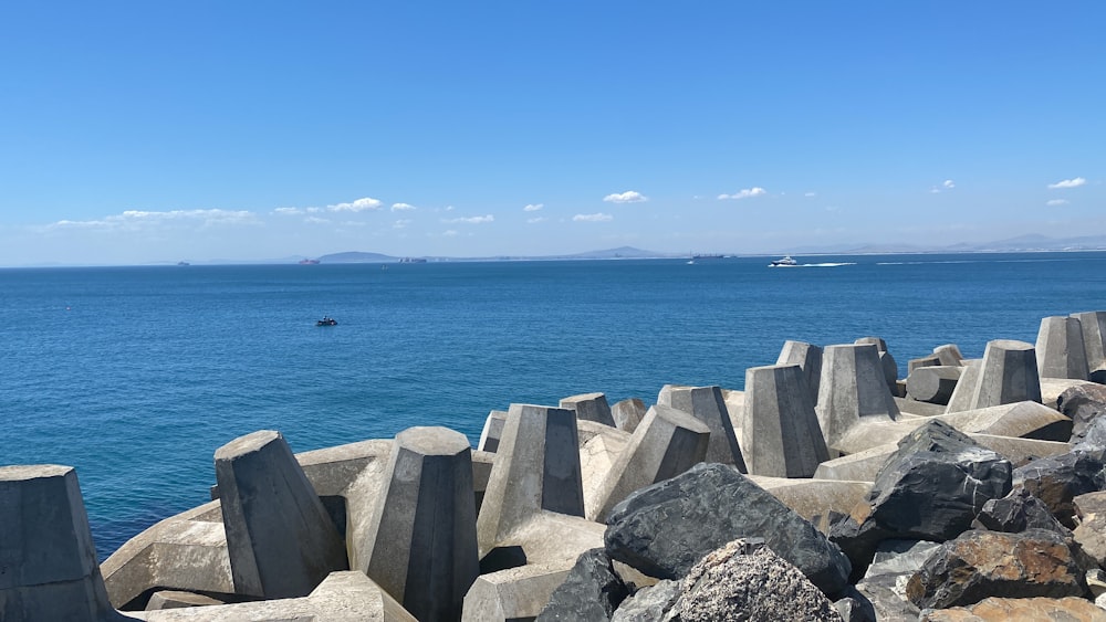 a large body of water sitting next to a rocky shore