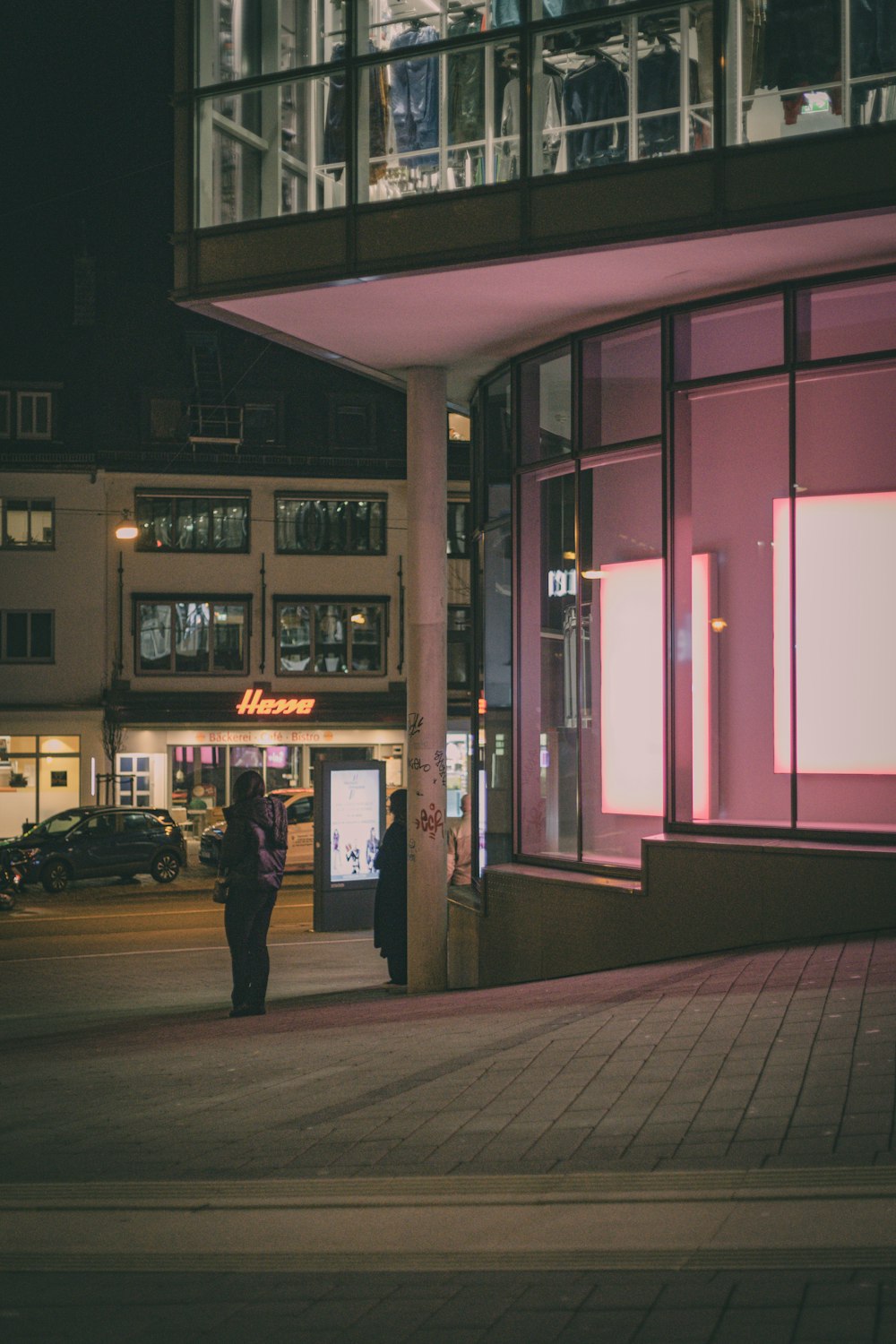 a person standing on a sidewalk in front of a building