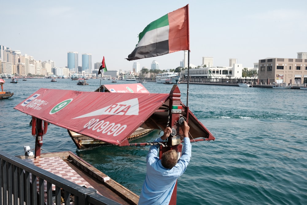 a man holding a flag on top of a boat