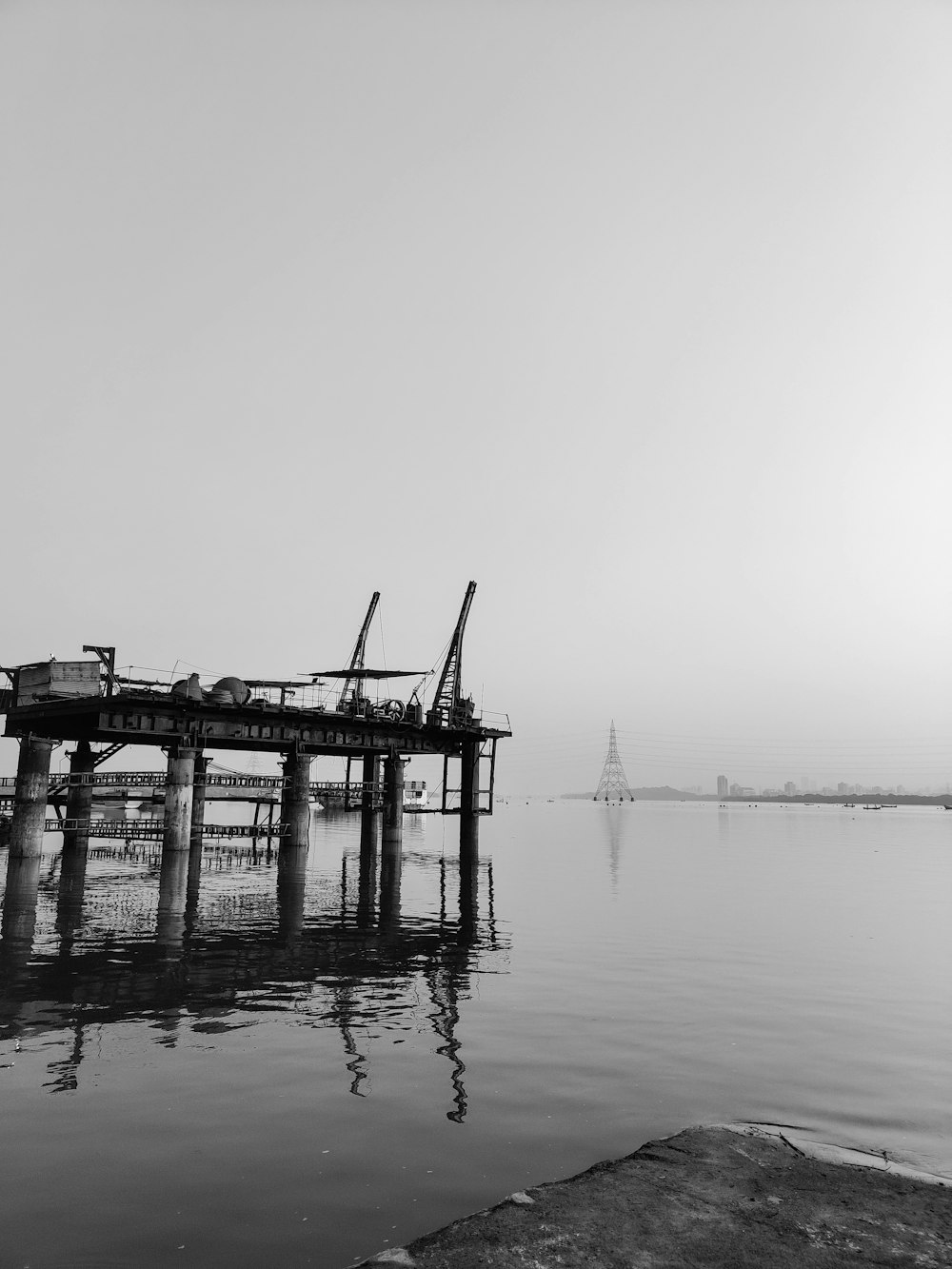 a black and white photo of a dock in the water
