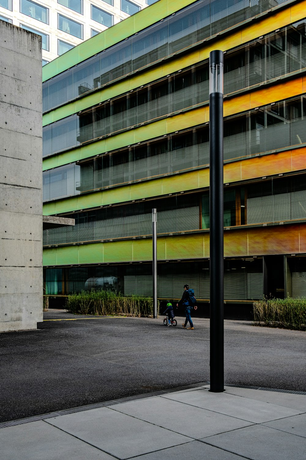 a person walking down a street next to a tall building