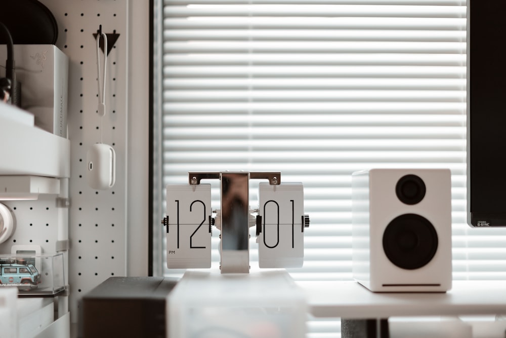 a desk with a computer and speakers on it