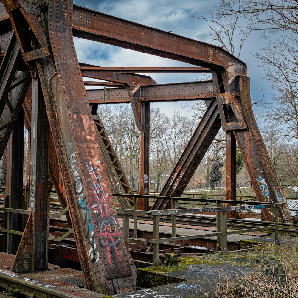 an old rusty bridge with graffiti on it