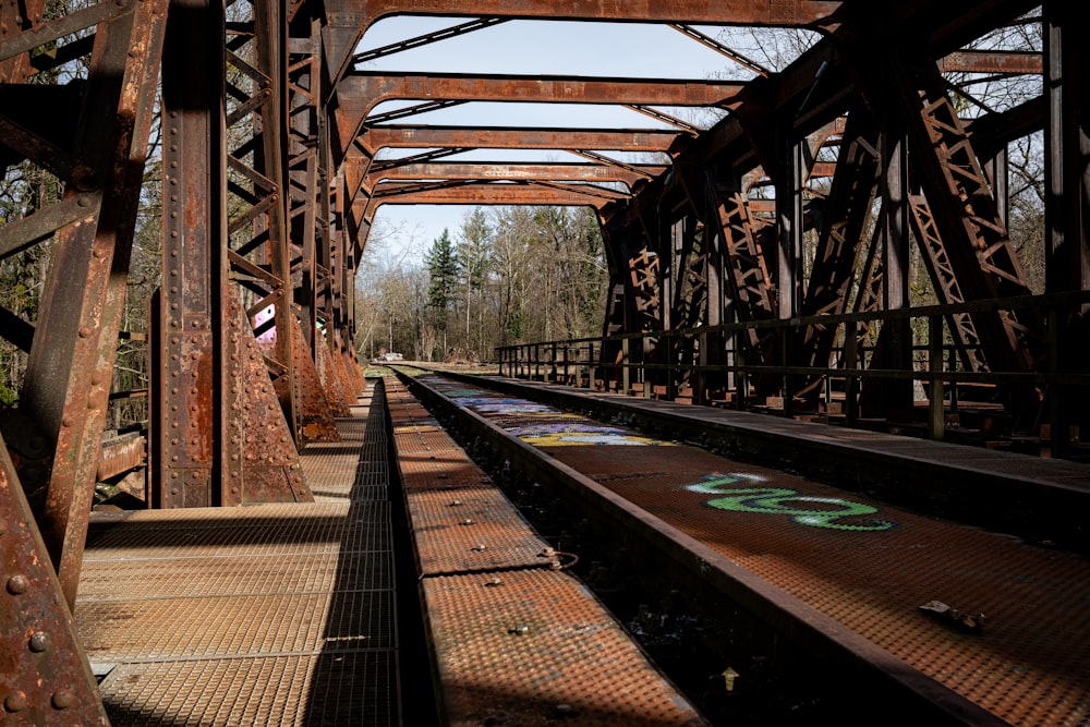 a railroad bridge with graffiti on the tracks