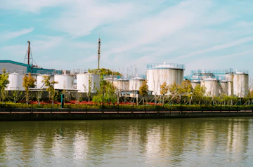 a body of water with a factory in the background