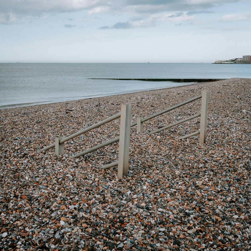 a couple of wooden posts sitting on top of a rocky beach