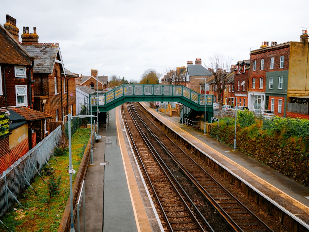 a train track with a green bridge over it