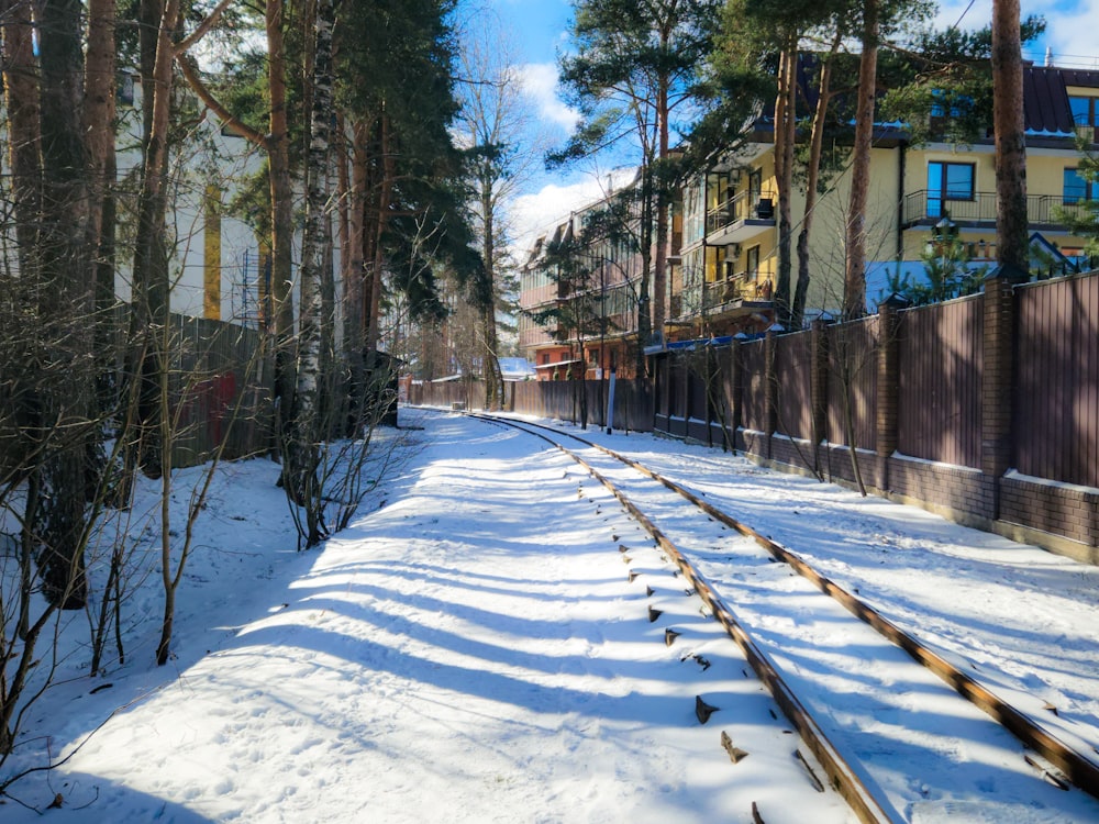 a train track running through a snow covered forest