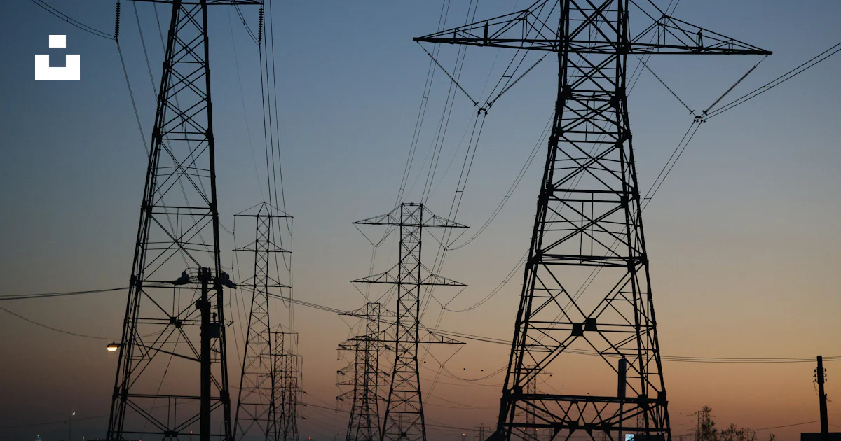 Steel transmission towers and power lines at dusk, representing energy infrastructure financing