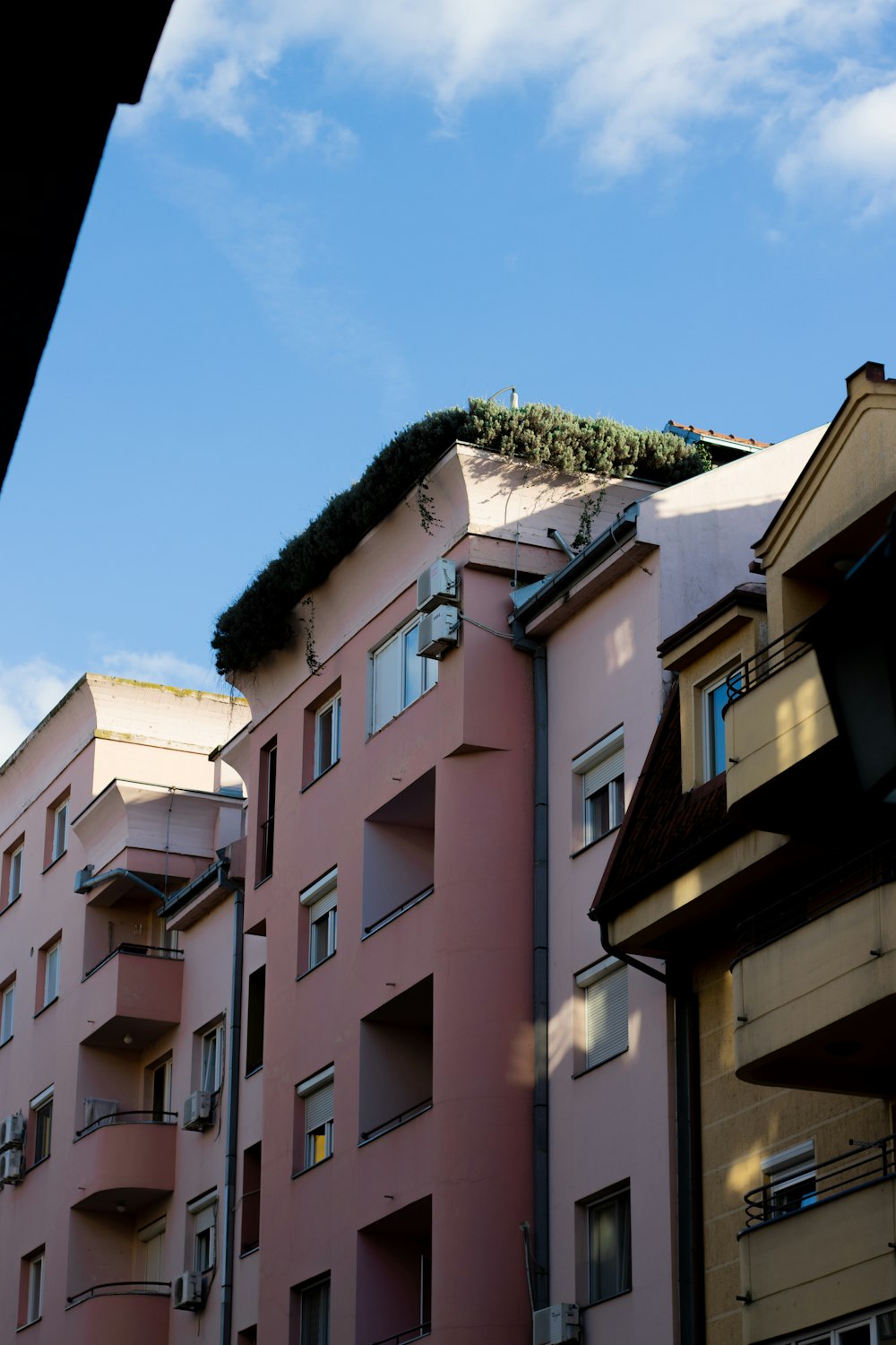 a pink building with a green roof