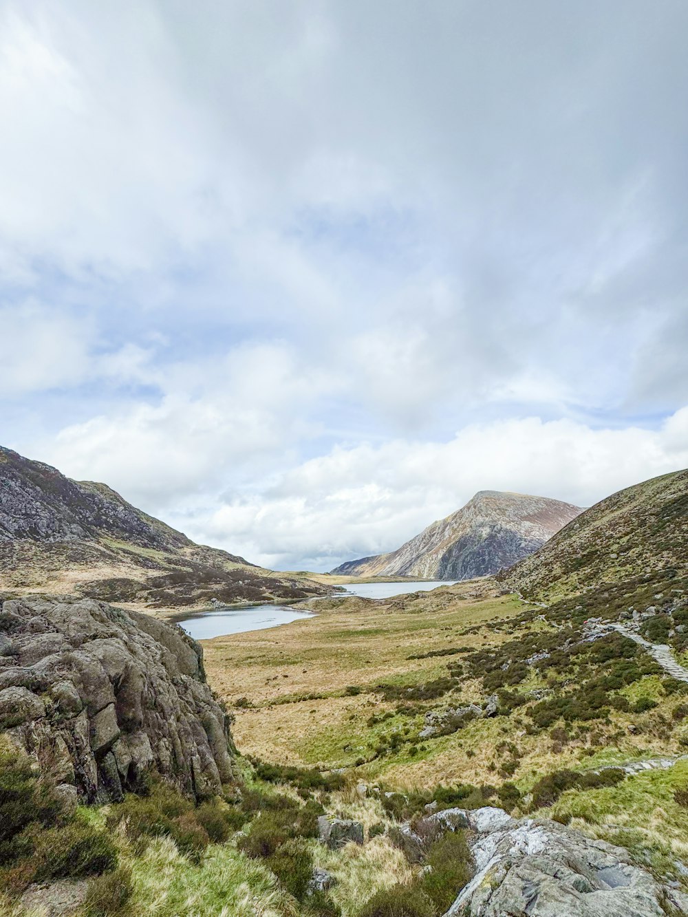 a view of a valley with a lake in the distance