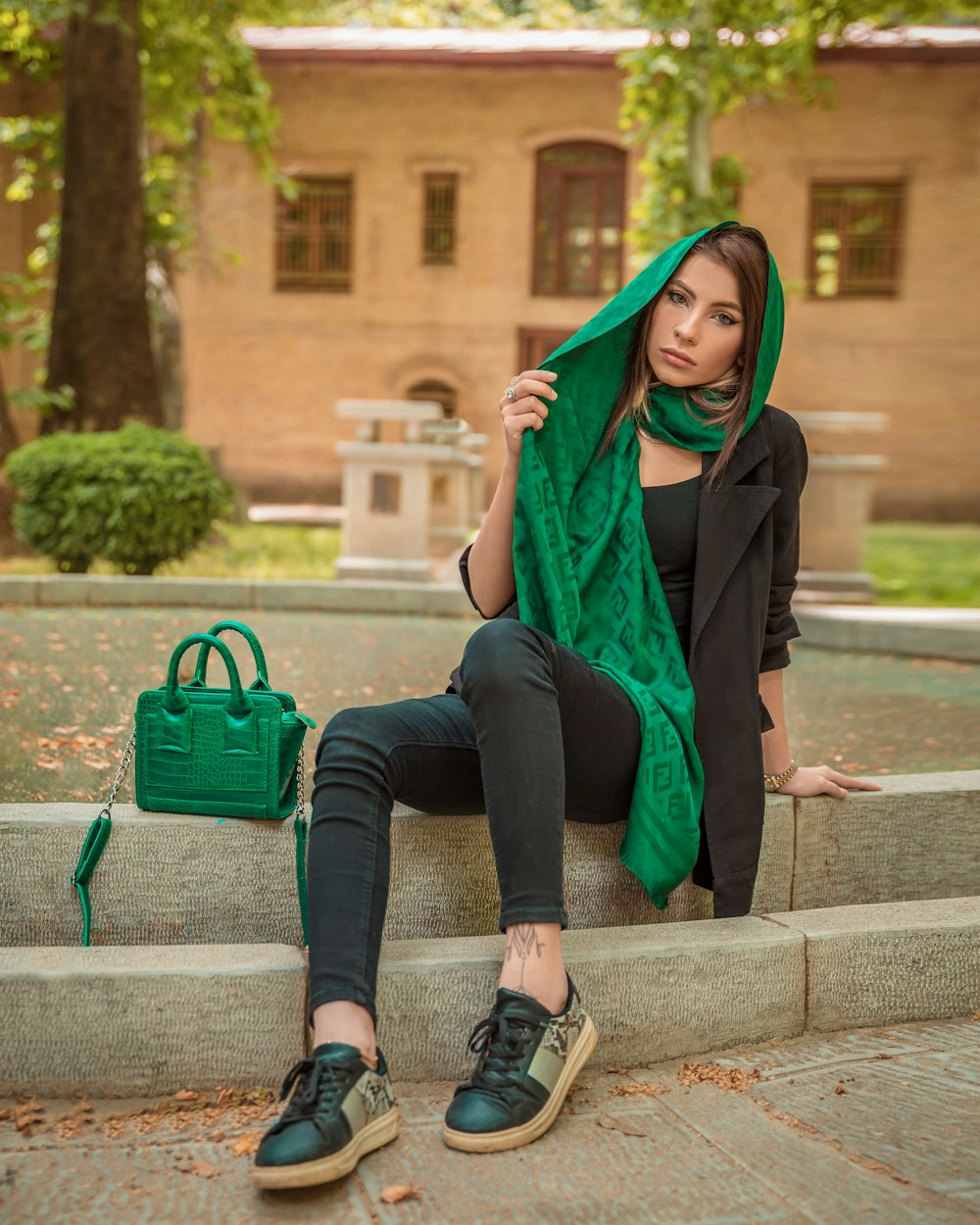 a woman sitting on steps with a green scarf over her head