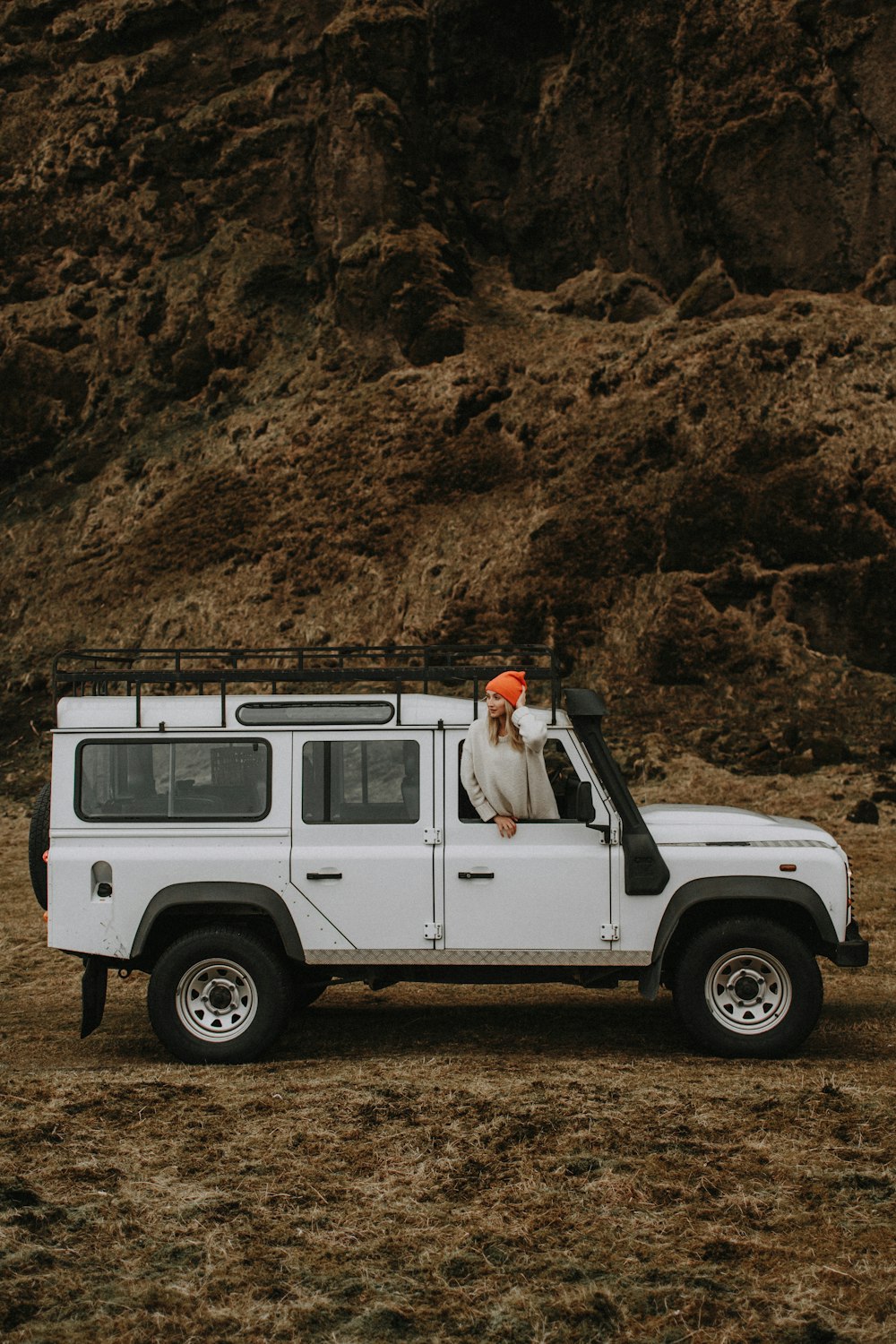 a white jeep with a bird sitting on top of it