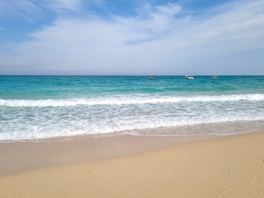 a sandy beach with waves coming in to shore