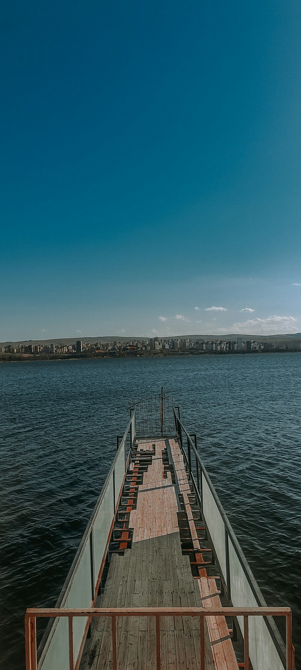 a wooden pier with benches on the side of it