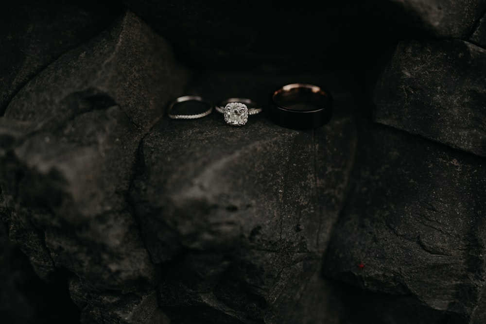 a couple of rings sitting on top of a rock