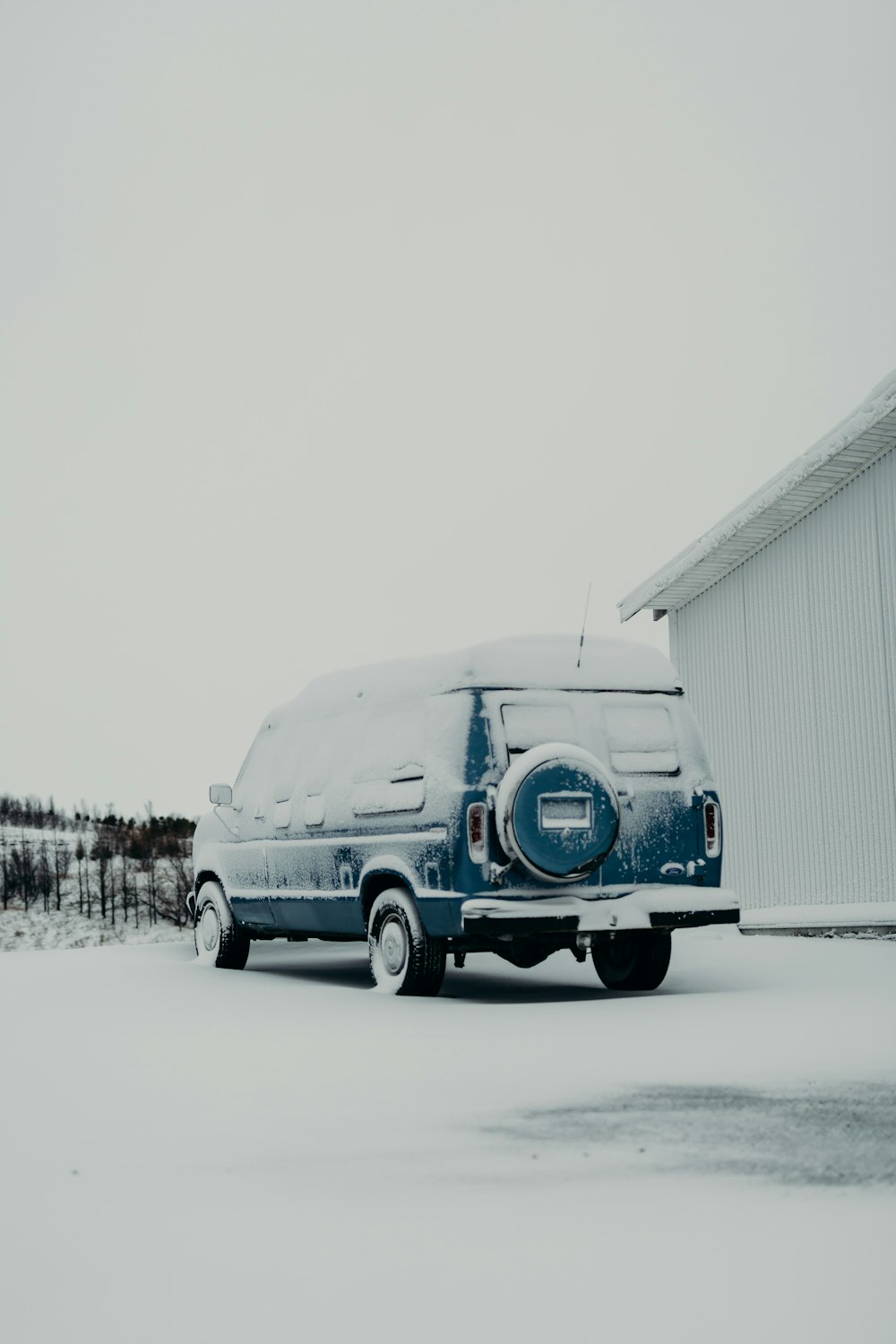 a van parked in front of a building covered in snow