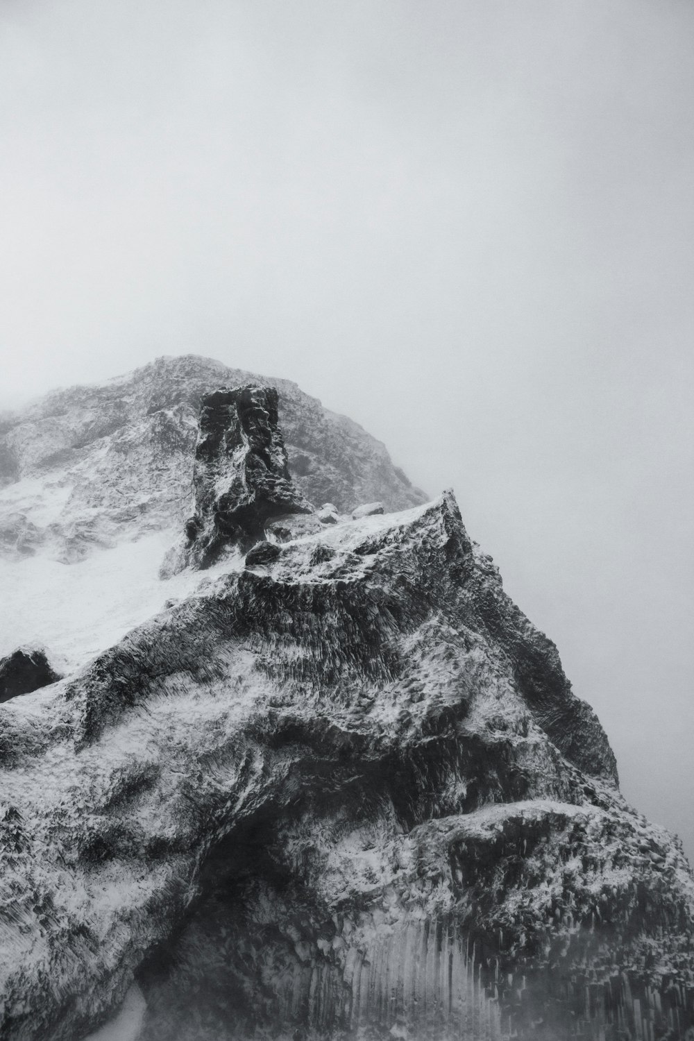 a very tall mountain covered in snow on a cloudy day